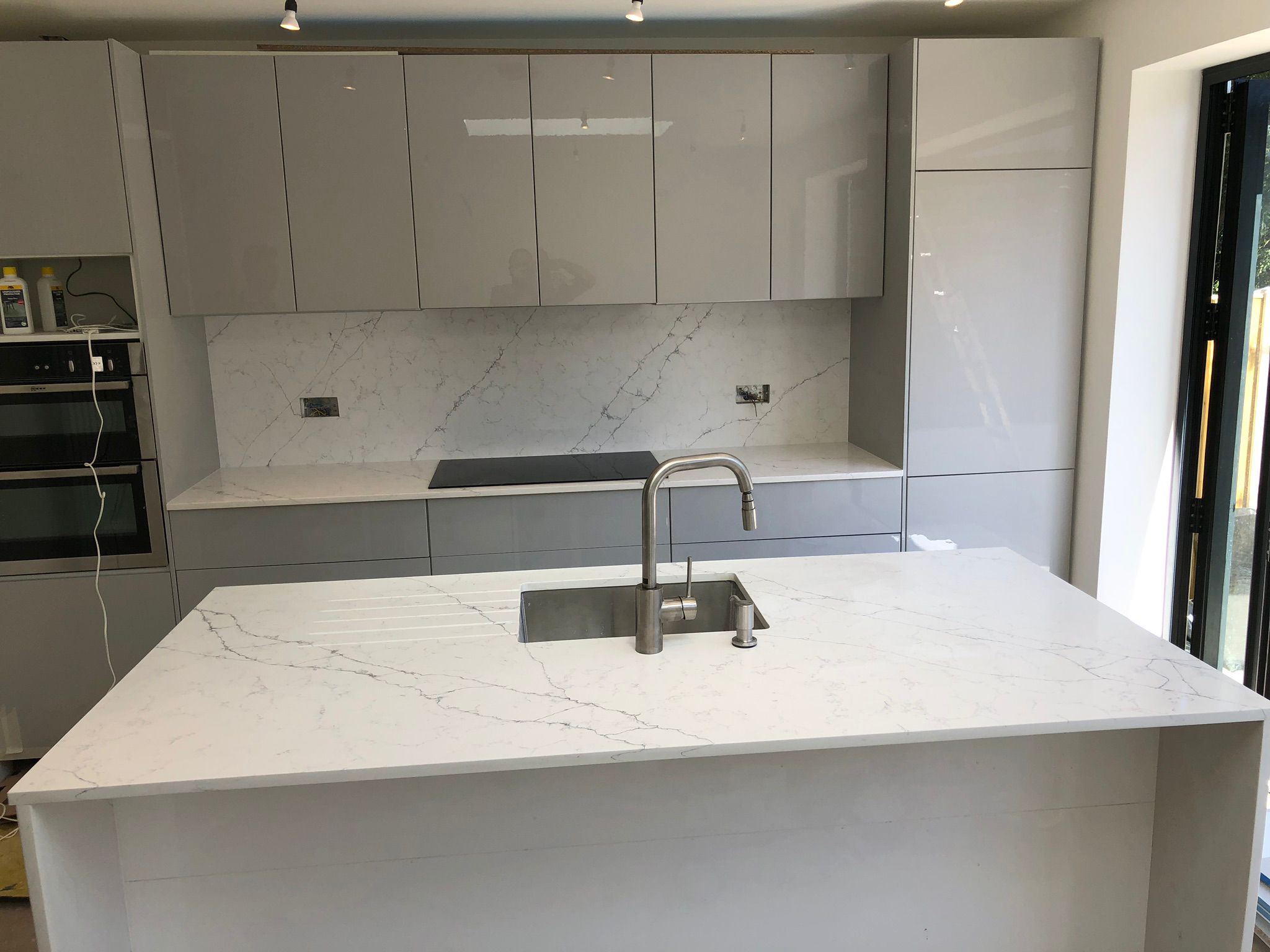 Calacatta marble island with grey kitchen cabinets